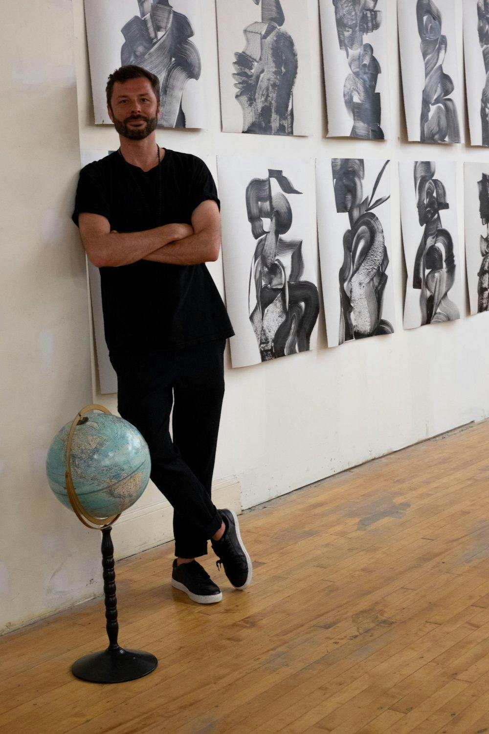 Tomek Sadurski with a selection of portraits from NAVIGATORS. Photo by Mana Parker.