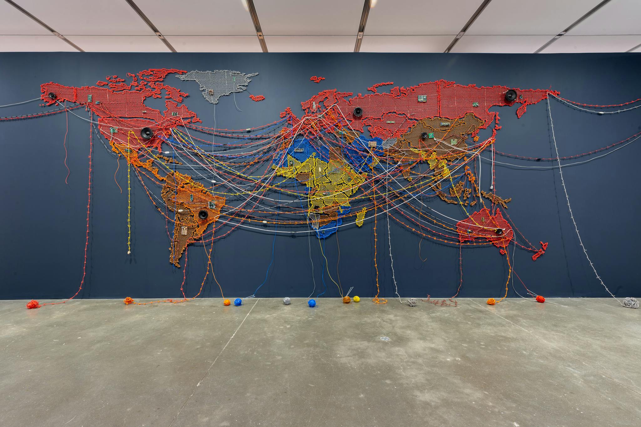 A colorful world map hangs from the wall, with threads linking different countries.