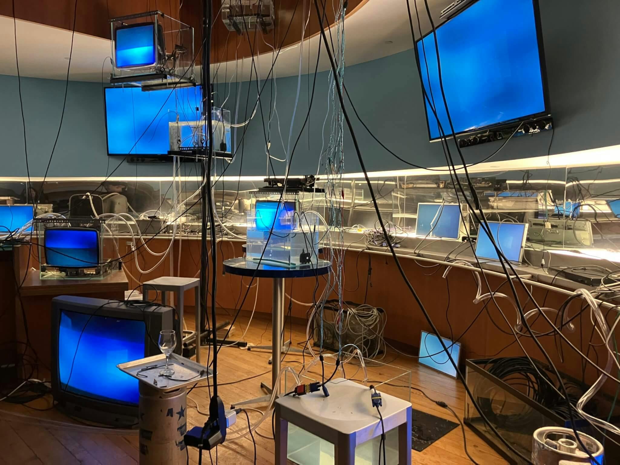 An assortment of blue screens with wires dangling from them fill the space.