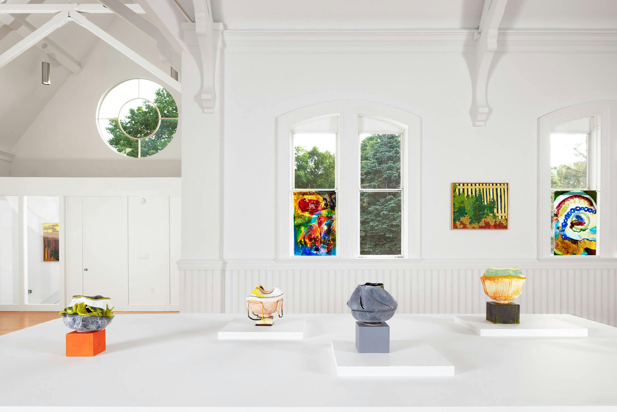Artworks on display in a white walled deconsecrated Catholic church.