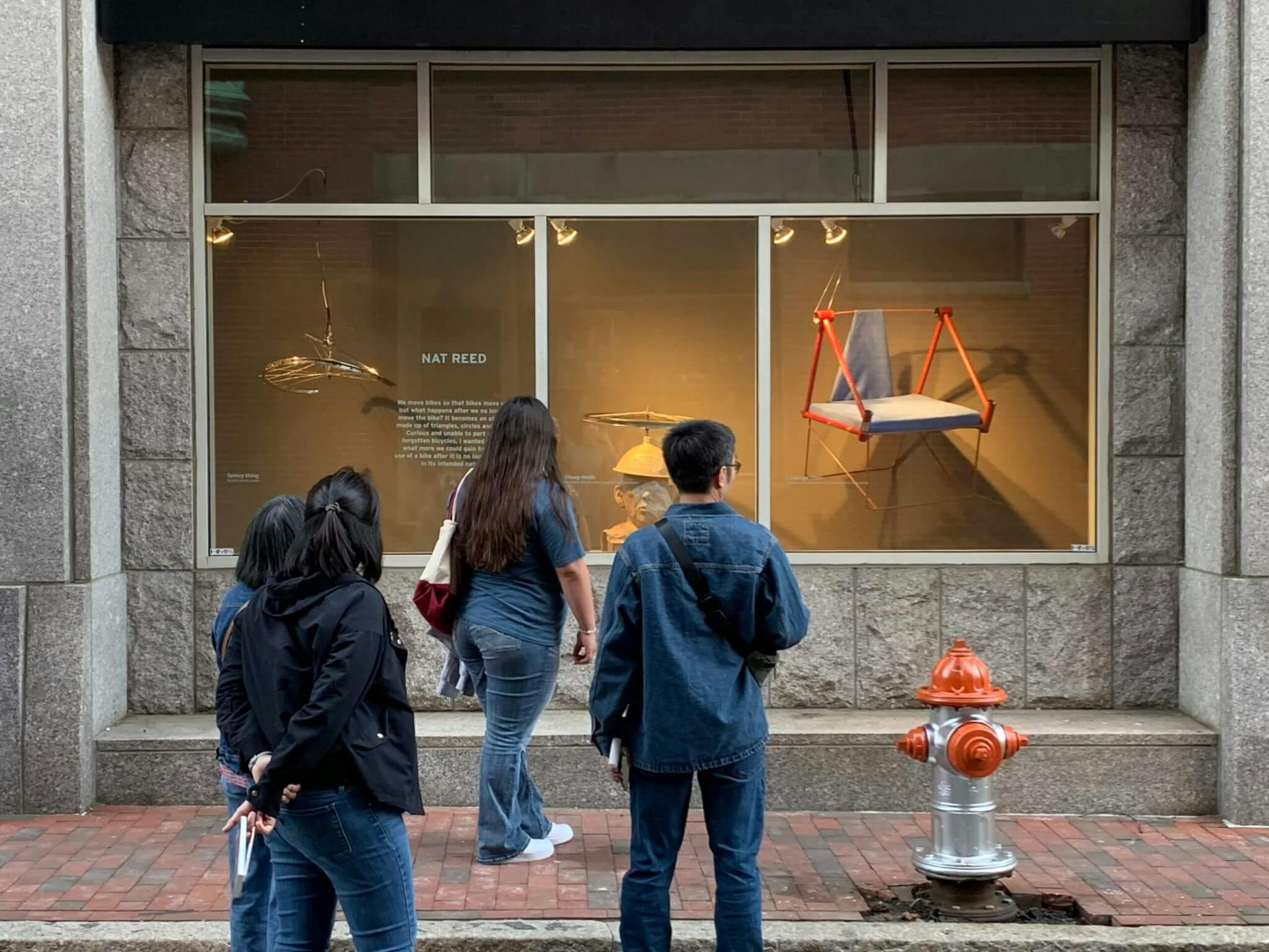 Image of passersby looking at "Bikes Move Us" installation