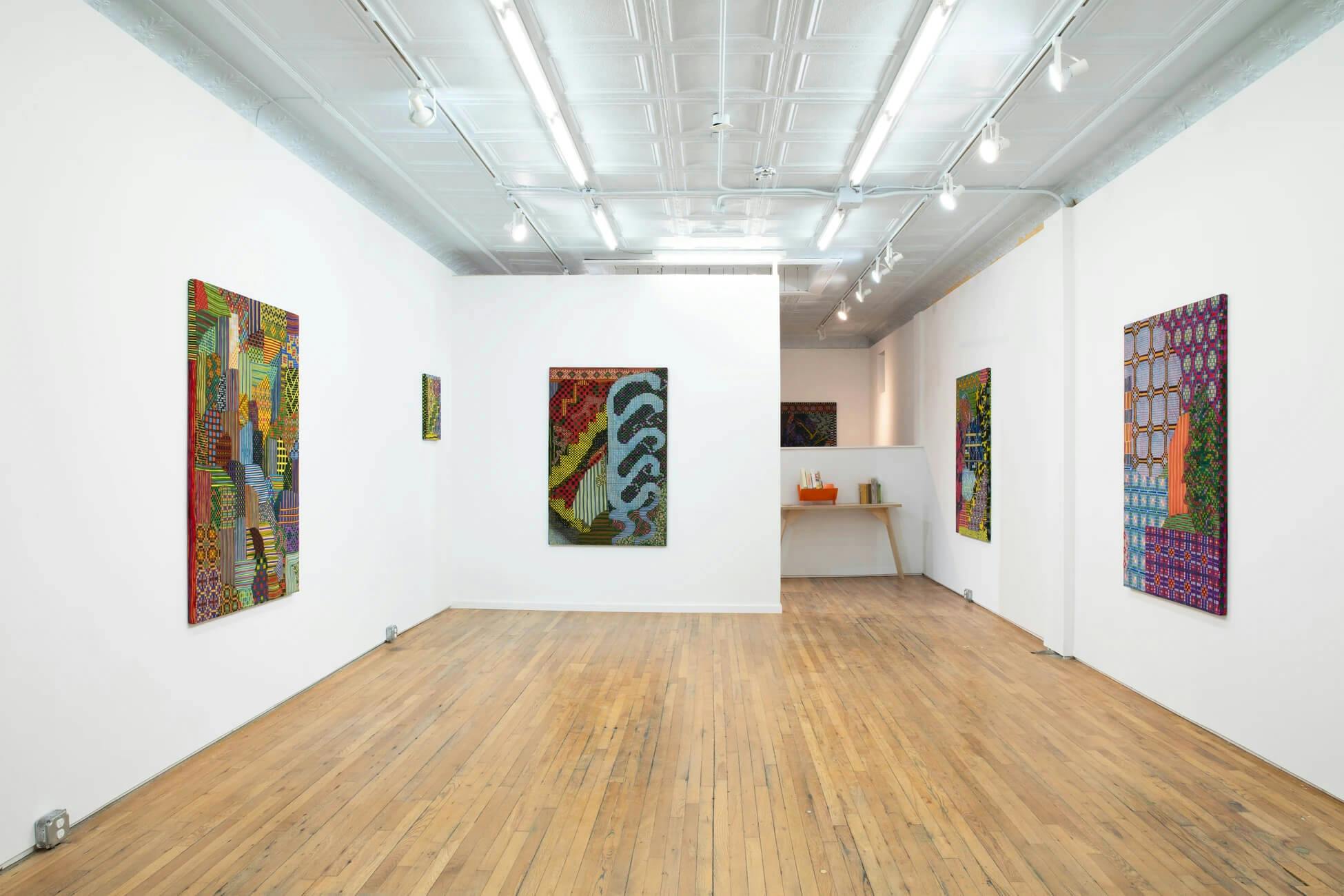 Colorful paintings on silk adorn the wall of the gallery for Lauren Luloff's solo show.