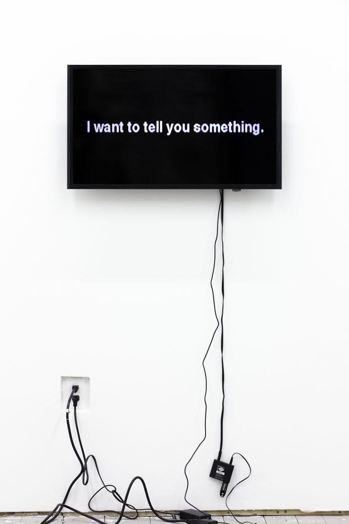 A screen with cords hanging from it displays a message.