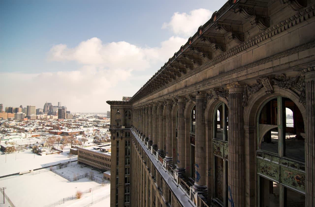 The outside of the Michigan Central Train Station, pictured beneath a blue sky.