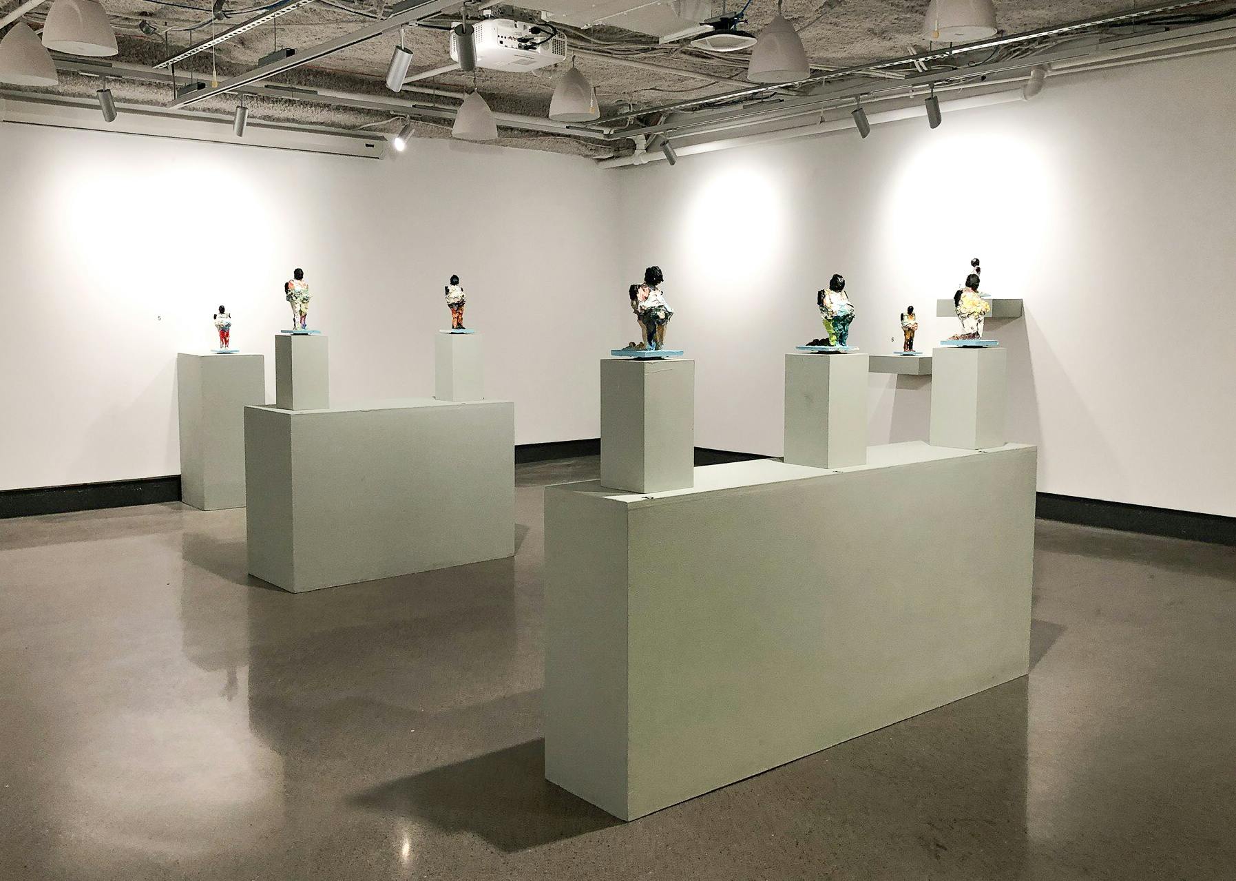 Small figures appear on white pedestals in Lavaughan Jenkins' exhibition.