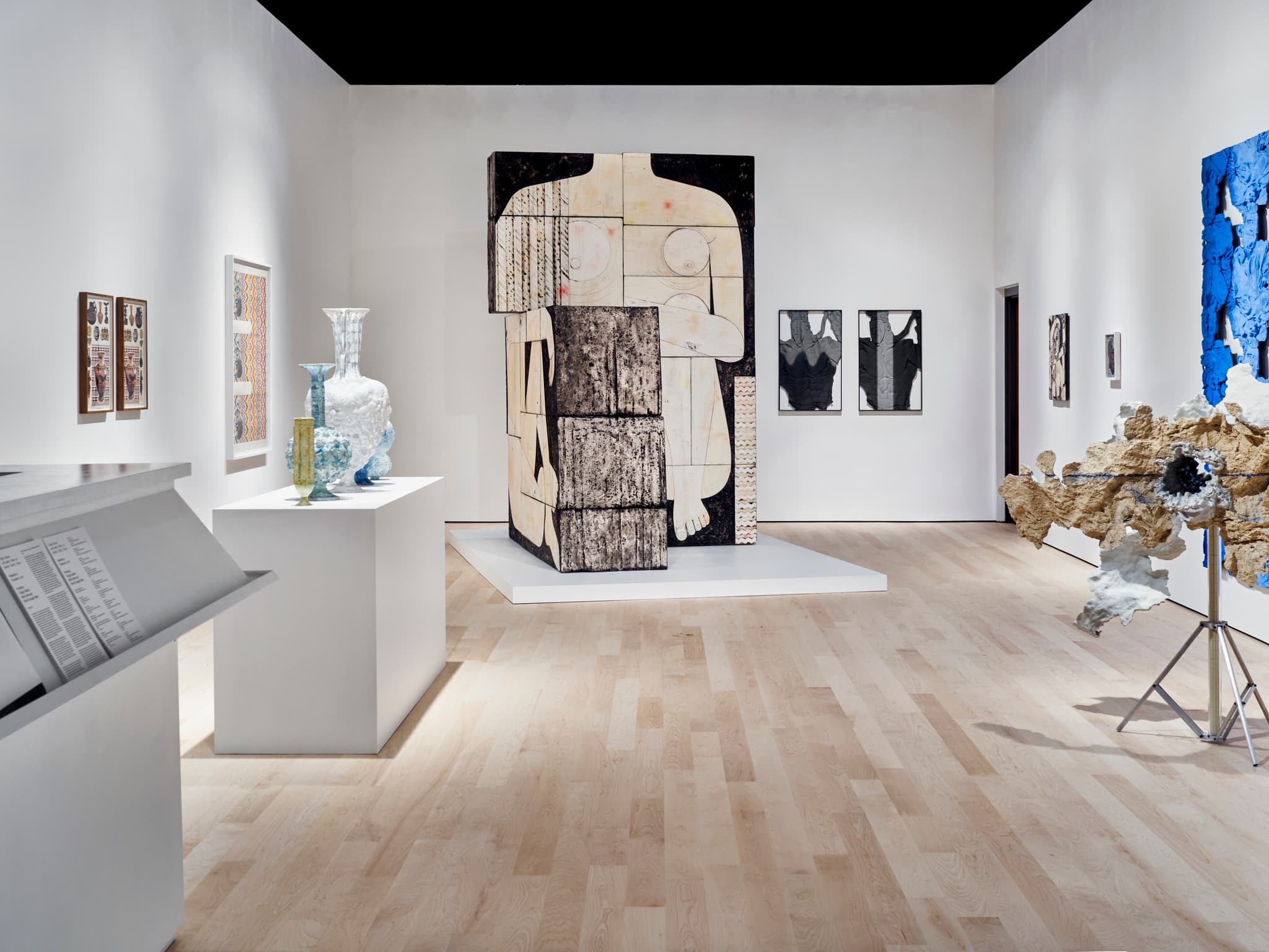 Against the far wall of the gallery space, the figure of a woman's form, made from foam, acrylic resin and thermal adhesive, is displayed, alongside other works.