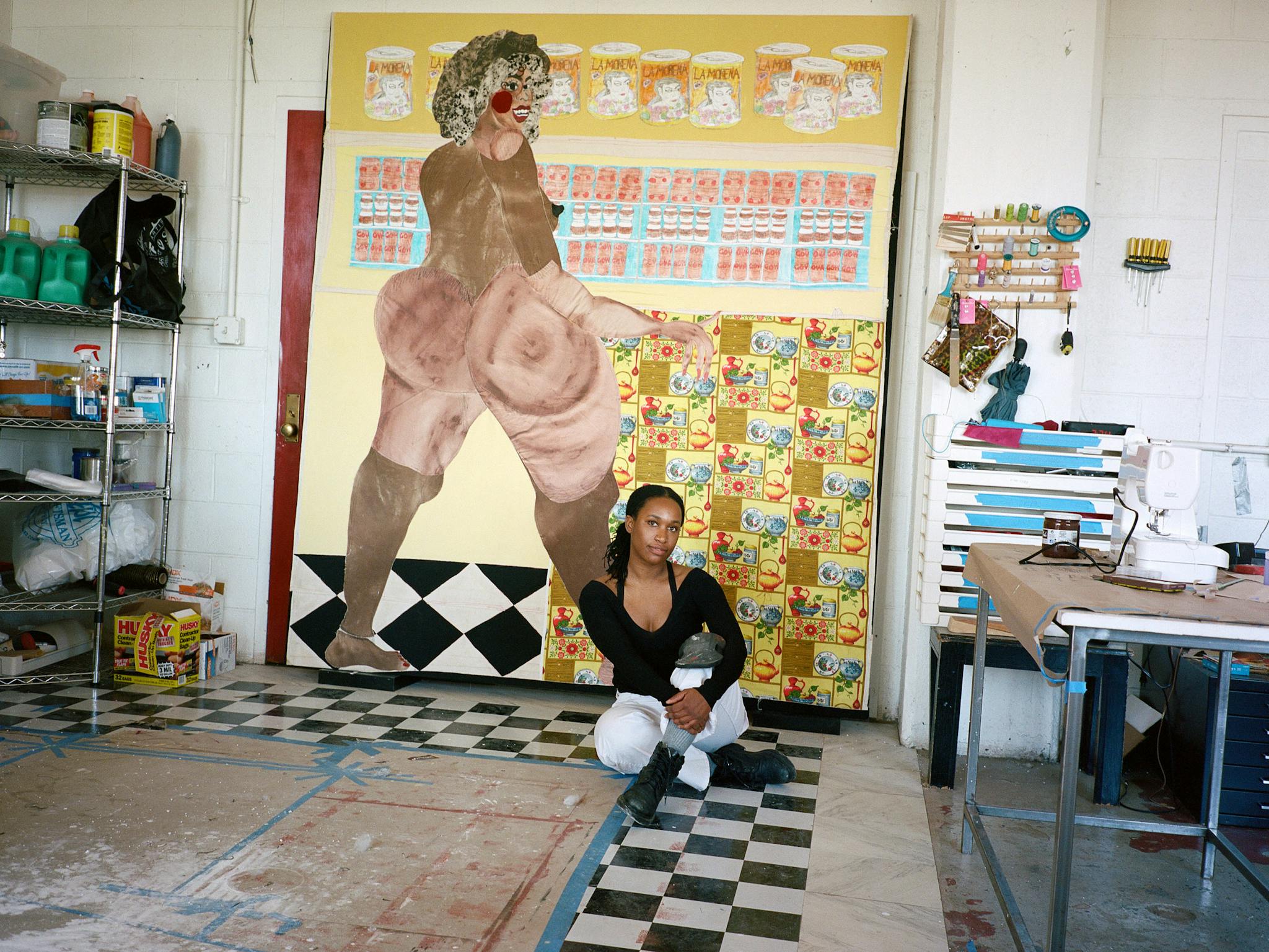 Tschabalala Self is in her studio, poised in front of a work that features that image of a woman's bare form.