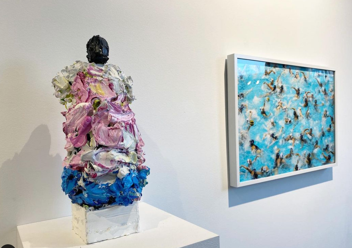 A colorful abstract sculpture and a photograph of individuals swimming in a pool at Abigail Ogilvy Gallery.