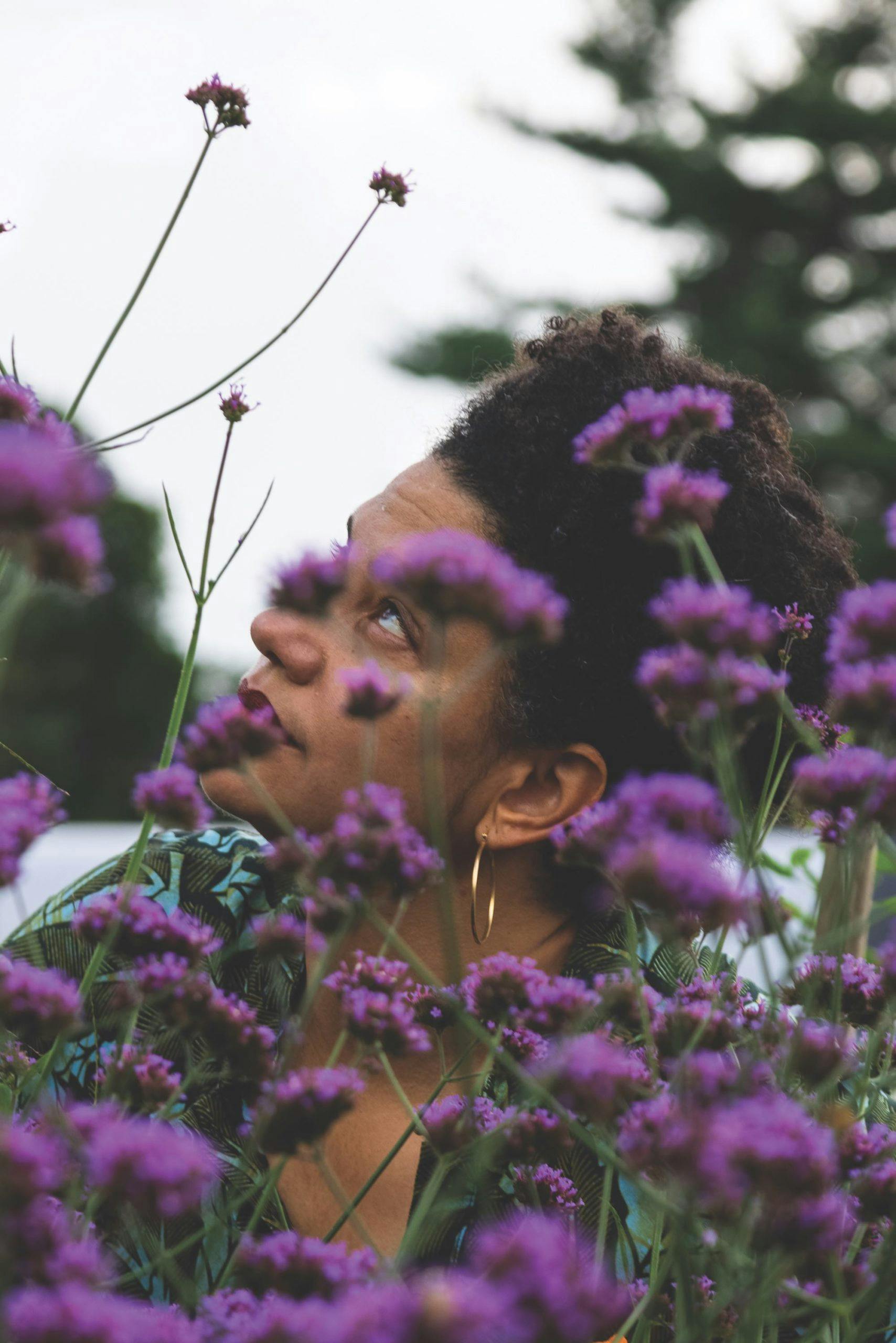 Jessica Roseman is photographed behind blossoming purple flowers.
