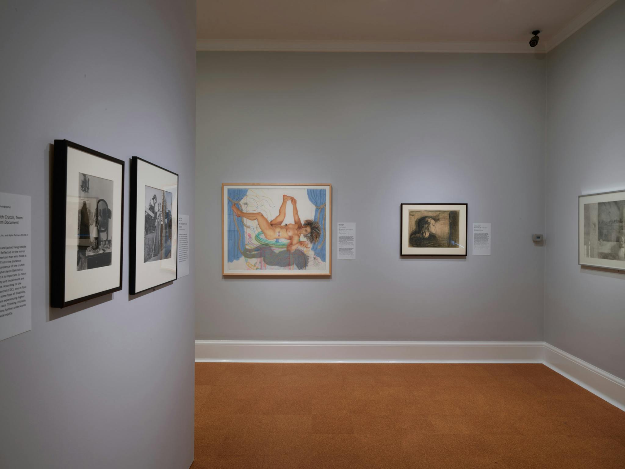 Photographs and other works of art displayed on the gray walls of the RISD Museum.