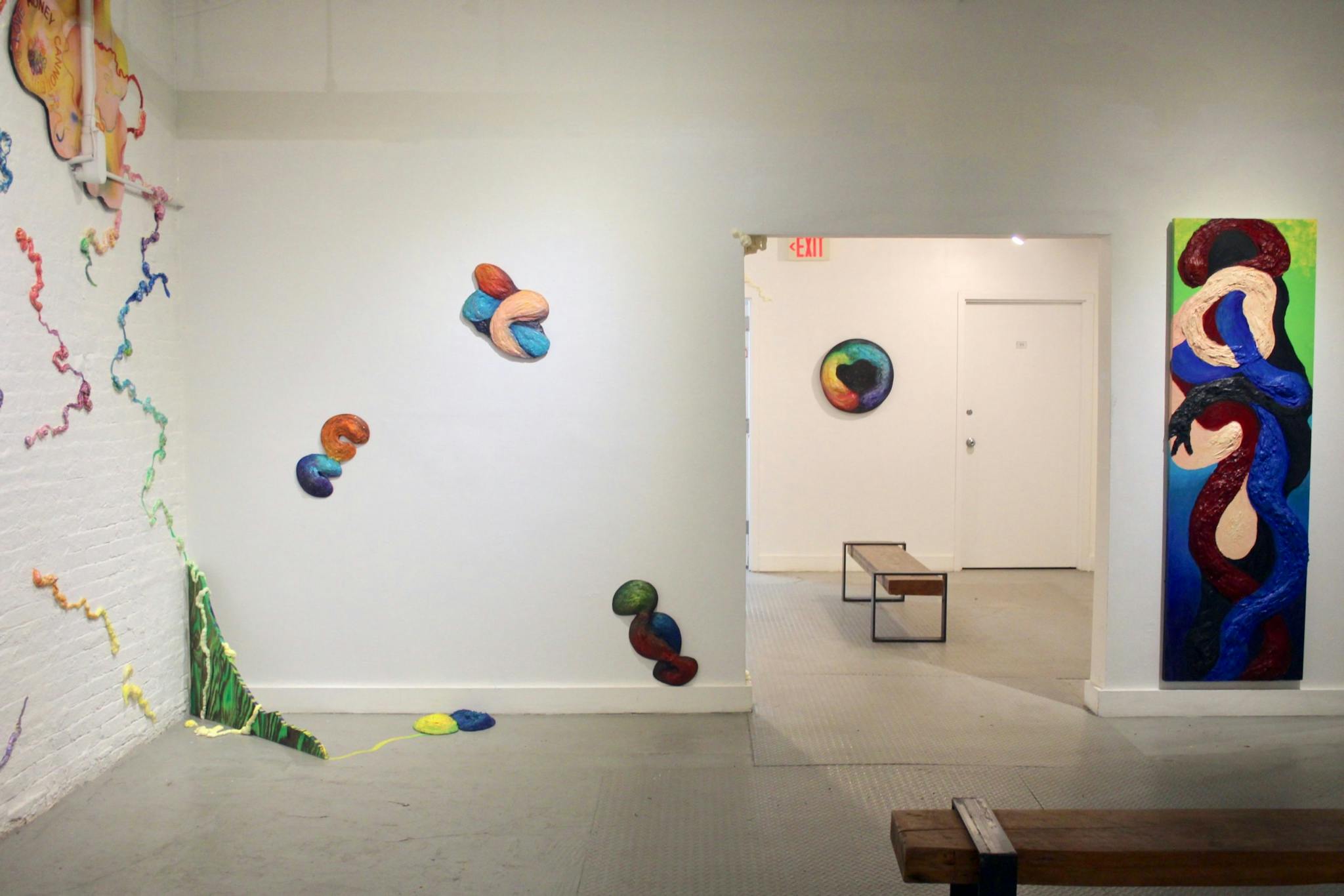 Colorful works adorn the white walls in Sunny Moxin Chen's installation.