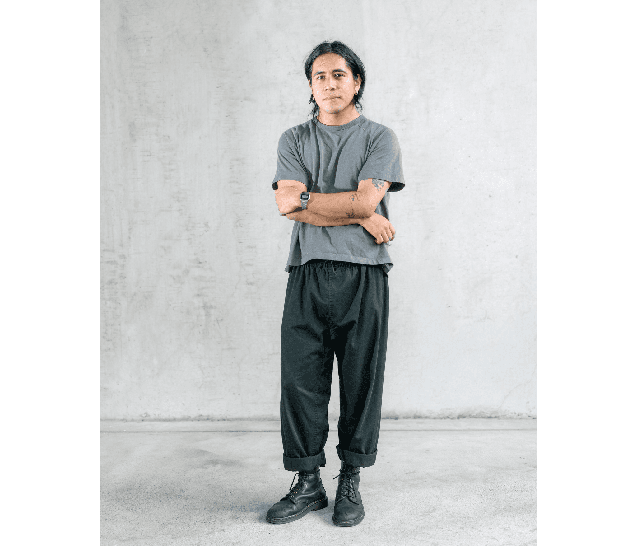 Mark Anthony Hernandez Motaghy stands in a gray t-shirt, arms crossed.