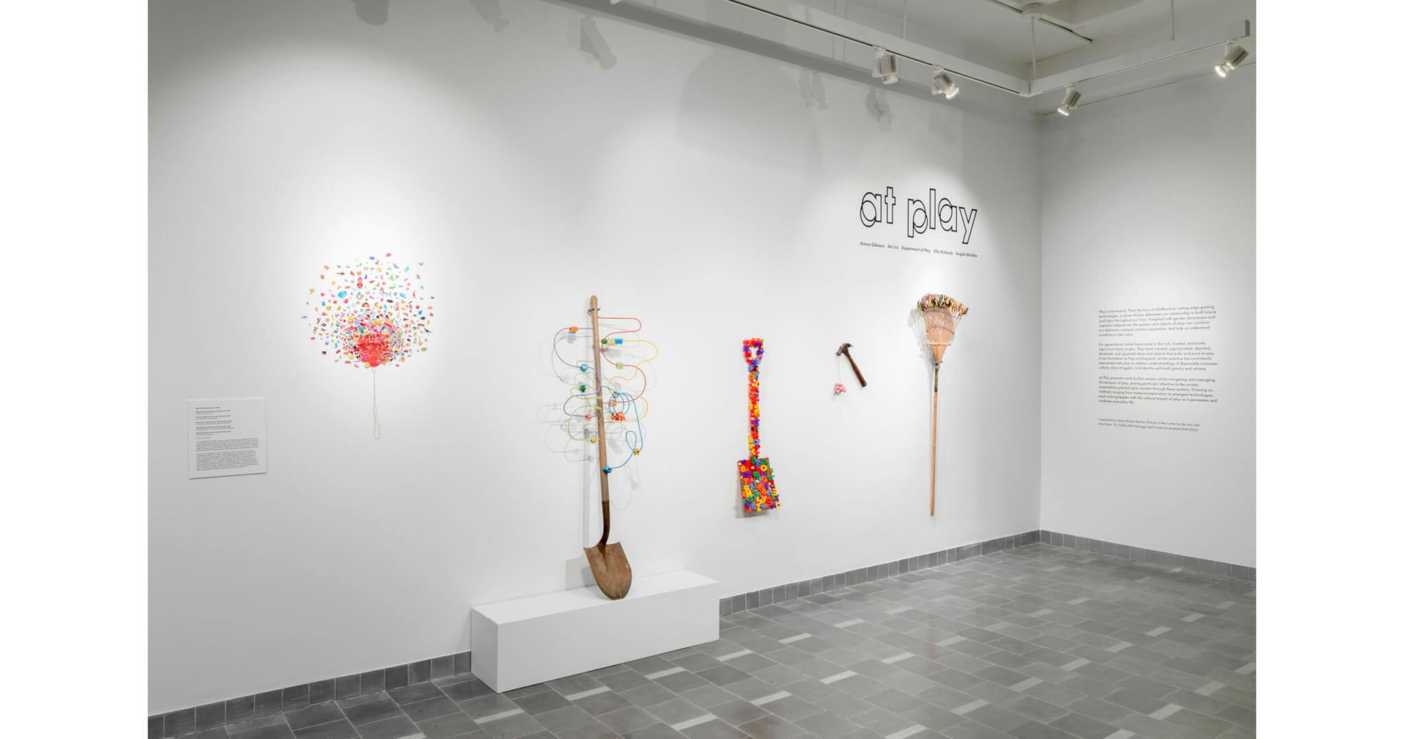 Rainbow colored artworks evoking play hang from a white wall in Northeastern's Gallery 360.