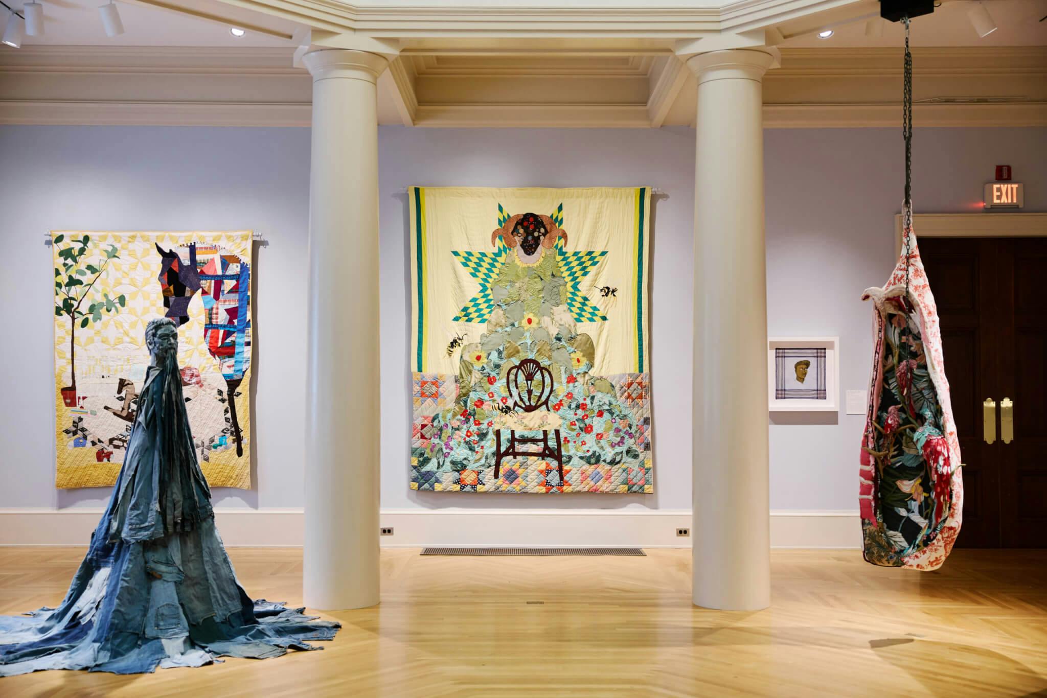 Colorful quilts hang from the walls of Newport Art Museum, while fabric-based installations also display in the space.