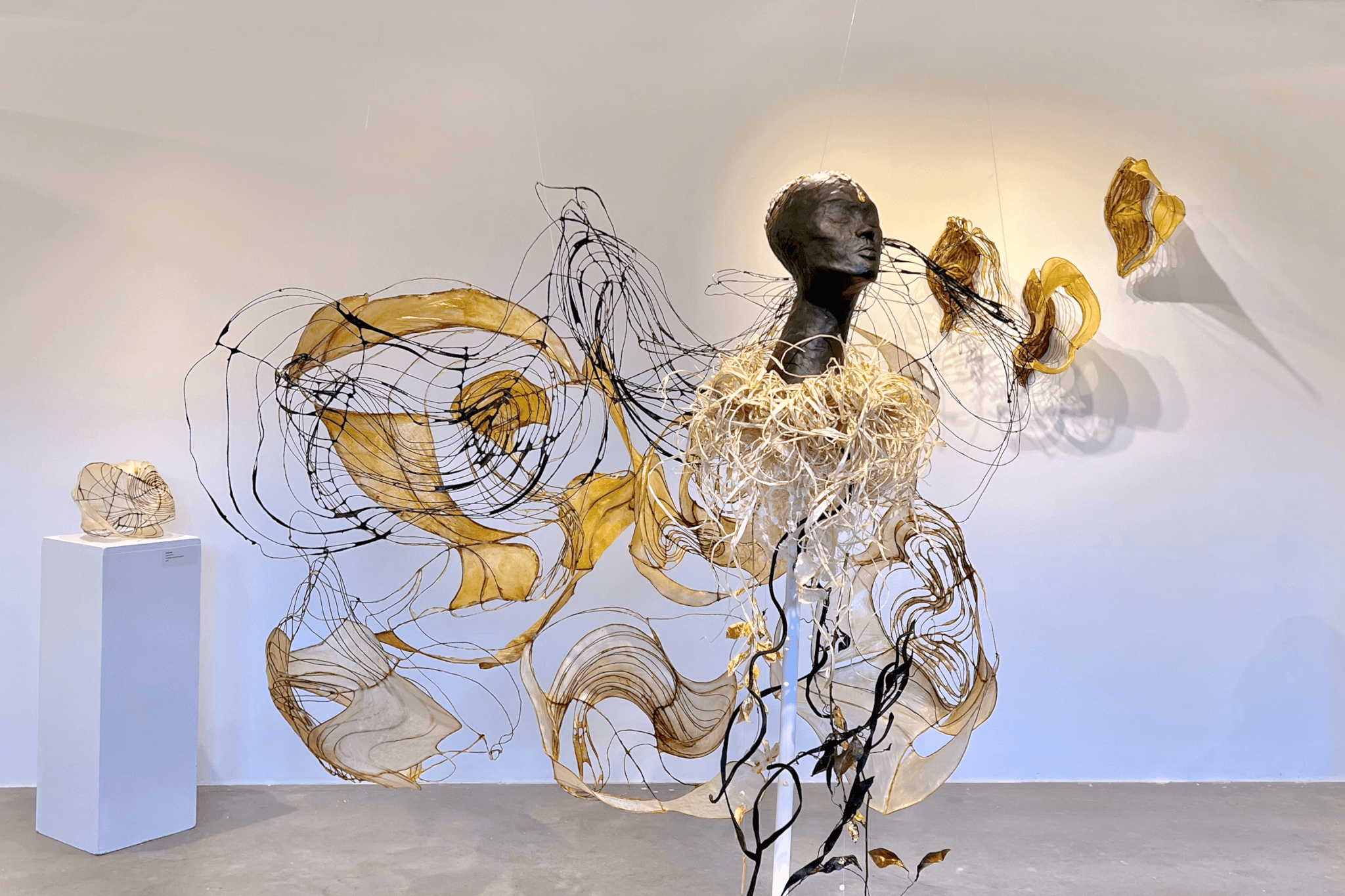 A swirling sculpture featuring the black form of an individual head arises in Fountain Street Gallery's space.