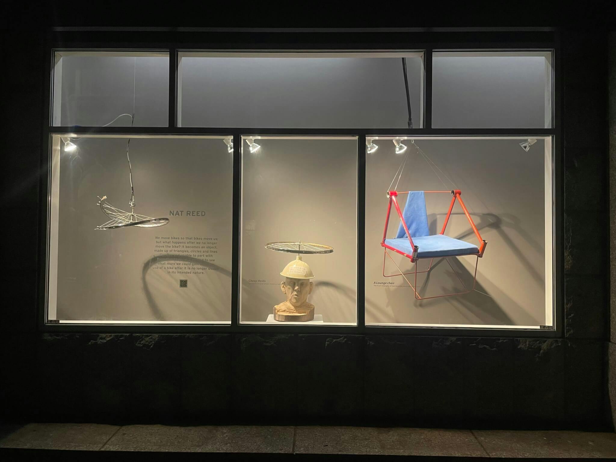 Suspended sculptures hanging behind a window.