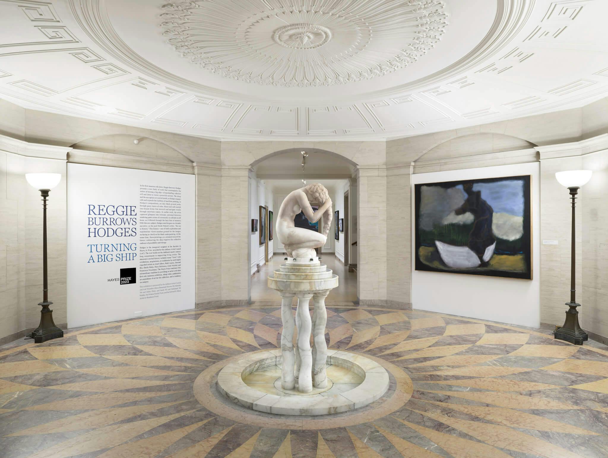 A white sculpture of the human form stands in the center of a grand space at the Addison Gallery of American Art.