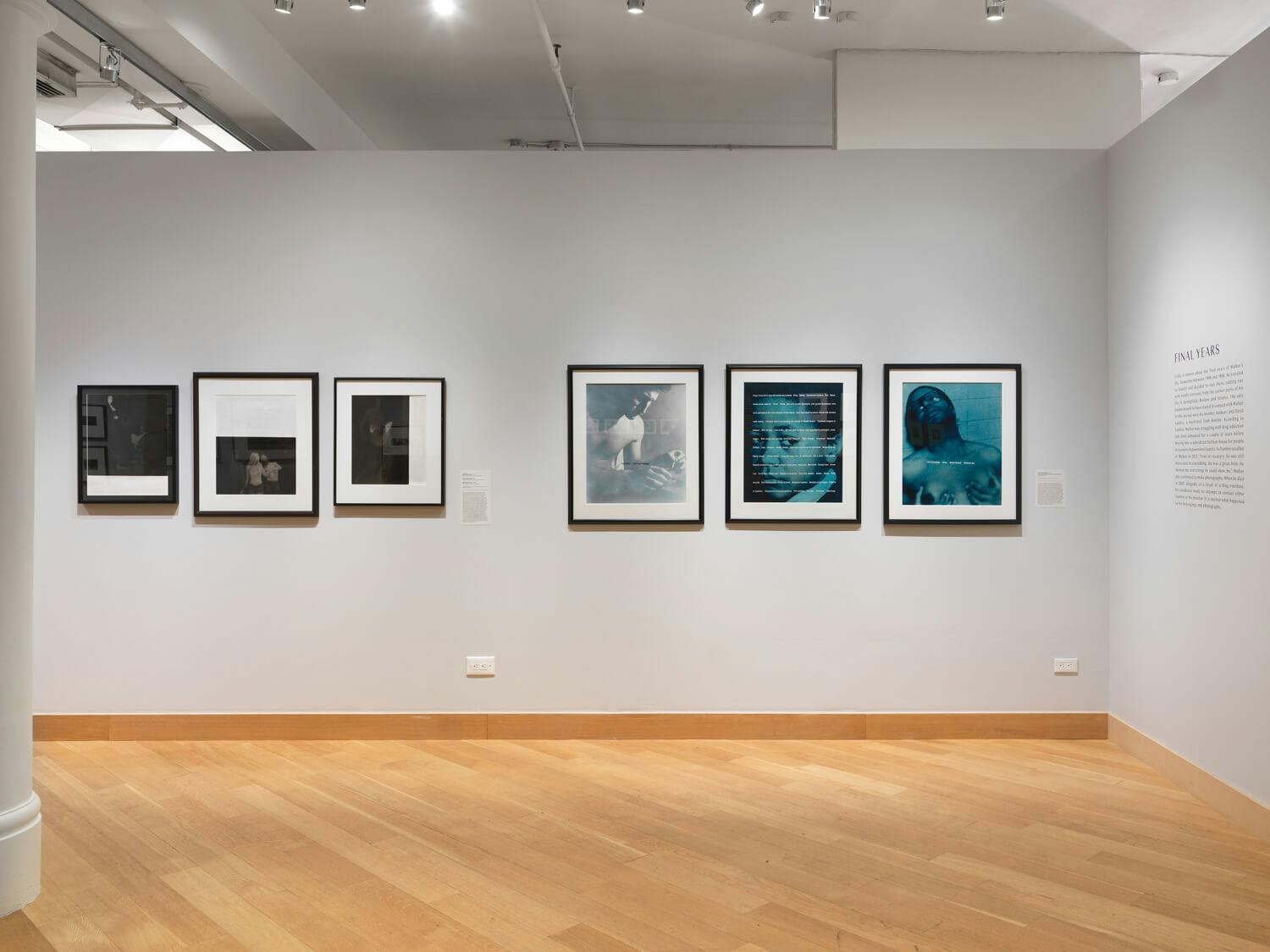 Christian Walker's photographs, some black and white, some blue toned, line the walls of a gallery.